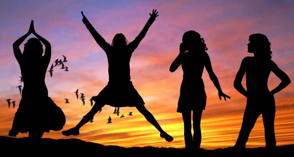 Four women at sunset in silhouette jumping and dancing