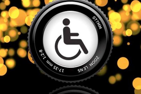 Handicap logo embedded in the center of a camera lense with blurry lights in the background.