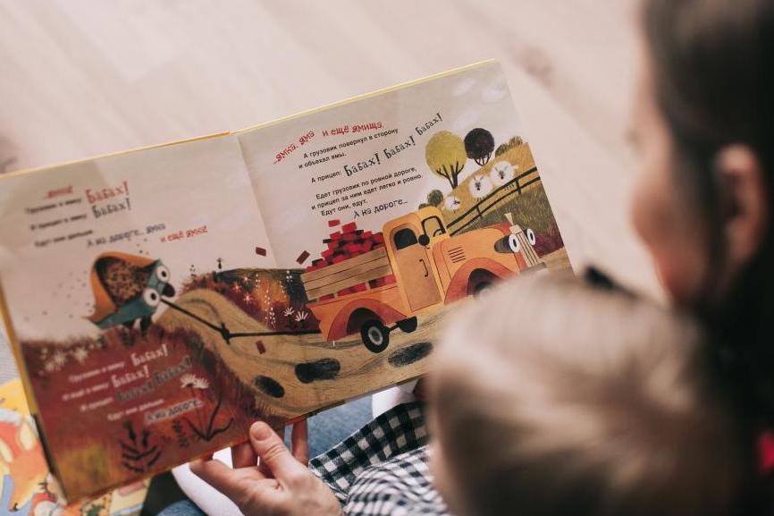 Woman reading book to toddler